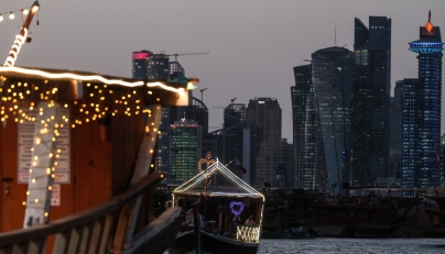 Traditional wooden boats are pictured against the backdrop of illuminated skyscrapers along the Corniche promenade in Doha on May 31, 2026. (Photo by Karim JAAFAR / AFP)
