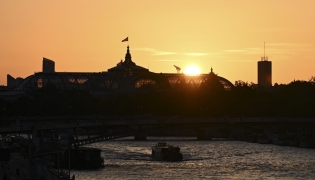 A tourist boat sails along the Seine river at sunset with the Grand Palais in the background, in Paris on 26 May 2026. (Photo by Christophe DELATTRE / AFP)
