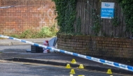 Police forensic marks are pictured behind a cordon at the scene of a stabbing on Kinnaird Avenue in north Belfast, Northern Ireland, on June 9, 2026. Photo by Paul Faith / AFP
