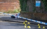 Police forensic marks are pictured behind a cordon at the scene of a stabbing on Kinnaird Avenue in north Belfast, Northern Ireland, on June 9, 2026. Photo by Paul Faith / AFP