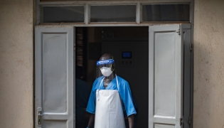 A health worker wearing a face mask as part of his personal protection equipment (PPE) looks on at the Mulago National Referral Hospital isolation unit in Kampala, Uganda, on July 8, 2026. Photo by BADRU KATUMBA / AFP