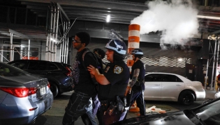 NYPD officers arrest a man after the New York knicks defeated the San Antonio Spurs in Game 5 of the NBA Finals to win the series, in New York, on June 14, 2026.
(Photo by kena betancur / AFP)