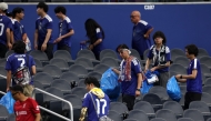Japan fans clear trash in the stands during the FIFA World Cup 2026 match at Dallas Stadium on June 14, 2026 in Arlington, Texas. Michael Steele/Getty Images/AFP 