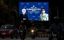 Commuters ride past an electronic board featuring Pakistan's Prime Minister Shehbaz Sharif (L) with Army Chief and Field Marshal Syed Asim Munir, displayed along a road in Islamabad on June 18, 2026 after the US–Iran peace deal announcement. Photo by Aamir Qureshi / AFP