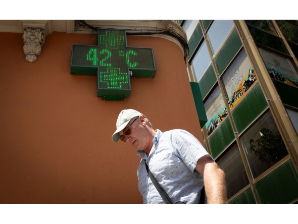 A tourist walks past a sign that reads 42 degrees Celsius in Palma de Mallorca on June 20, 2026, on the eve of the start of the first official heatwave of this summer. Photo by Jaime REINA / AFP