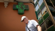 A tourist walks past a sign that reads 42 degrees Celsius in Palma de Mallorca on June 20, 2026, on the eve of the start of the first official heatwave of this summer. Photo by Jaime REINA / AFP