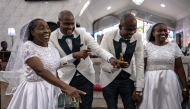 Grooms and brides dance during their wedding ceremony at the Bishop Akinyele Memorial Anglican Church in Ibadan, on June 20, 2026. (Photo by OLYMPIA DE MAISMONT / AFP)