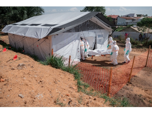 Members of specialized response teams enter the morgue of the Evangelical Medical Center of Nyankunde (CME) with the body of a person who died from Ebola virus disease to allow relatives to pay their last respects after washing, disinfection and safe body-wrapping procedures in Bunia, Ituri Province, Democratic Republic of Congo, on June 13, 2026. (Photo by Jospin Mwisha / AFP)