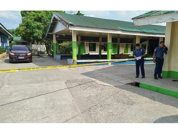 Policemen stand near the crime scene of a school compound after a shooting incident at a high school compound in Tacloban City, Leyte province on June 22, 2026. (Photo by Noel Sianosa / AFP)
