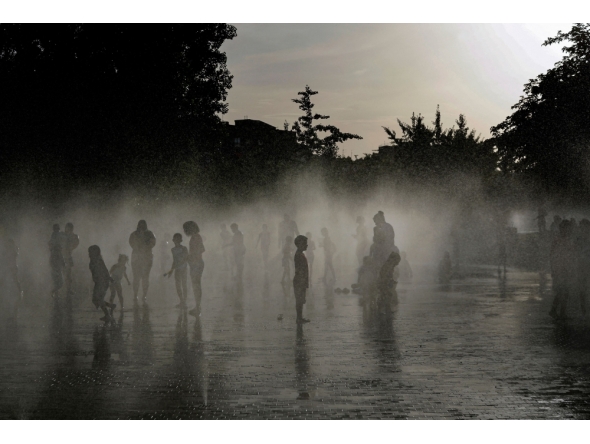 People off in a water fountain as Spain experiences a heatwave, in Madrid. (Photo by Oscar Del Pozo / AFP)