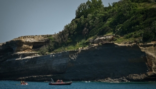 Firefighters search by boat at the base of the cliff from which a section collapsed near Miramar beach, killing one woman and leaving a diver missing, in Biarritz, south-western France, on June 25, 2026. Photo by PHILIPPE LOPEZ / AFP