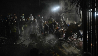 Rescue workers and volunteers search through the rubble of a collapsed building in Caracas on June 25, 2026, following a series of earthquakes. Photo by Maryorin Mendez / AFP