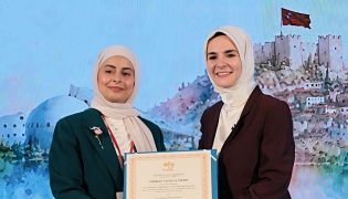 Head of the Family Affairs Section at the Ministry of Social Development and Family Sheikha Ali Al Marri receives a certificate during the event.