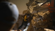 People search for their deceased relatives among the debris of a collapsed building in the Los Corales neighbourhood of Caraballeda, La Guaira State, Venezuela on July 1, 2026, following the June 24 twin earthquakes. (Photo by Federico PARRA / AFP)