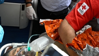 An international rescue team assists a survivor of Venezuela's twin earthquakes in Catia La Mar, La Guaira State, Venezuela on July 2, 2026, eight days after the quake. Hernan Gil, a 43-year-old security guard, had been buried in the booth of the seven-story building where he worked in Catia La Mar, a coastal area in the state of La Guaira devastated by the disaster. (Photo by Federico PARRA / AFP)
 