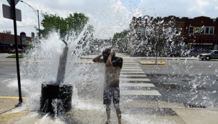 A person cools off with water from an open fire hydrant during a heat wave on the West Side of Chicago, Illinois, on July 2, 2026. (Photo by Octavio Jones / AFP)