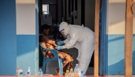 A healthcare worker takes samples from a patient suffering from Ebola virus disease at the Ebola Treatment Center of the Center Médical Évangélique (CME), in Bunia, Ituri, in the east of the Democratic Republic of Congo on June 23, 2026. (Photo by Benediction MURHABAZI / AFP)