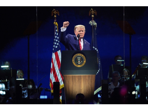 US President Donald Trump raises his fist while speaking at 