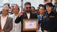 (Files) Rastriya Swatantra Party (RSP) election candidate Balendra Shah (C) shows a victory sign after collecting a certificate following his win in parliamentary elections at the counting centre in Damak in Nepal's Jhapa district on March 7, 2026. Photo by Prakash Mathema / AFP