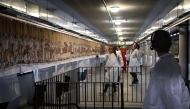 Workers and volunteers, rest before preparing to pack the Bayeux Tapestry in a crate for transfer to the British Museum, at the Bayeux Tapestry Museum, in Bayeux, northwestern France, on September 18, 2025. Photo by Lou Benoist / Pool / AFP
