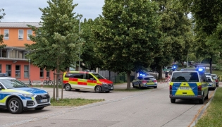 Cars by Police and rescue personnel are parked near the secondary school Schongau, in the southern German state of Bavaria, where several people have been wounded and a suspect arrested in an attack on July 8, 2026.  (Photo by Christoph PETERS / DPA / AFP)