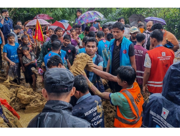 Bangladesh rescue personnel and volunteers work at the site of a landslide triggered by heavy rains at a school in the Kutupalong refugee camp in Cox's Bazar on July 8, 2026. (Photo by AFP)
 