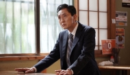 Japanese actor Yutaka Matsushige performs a dining scene during the filming of an episode of the TV drama series 