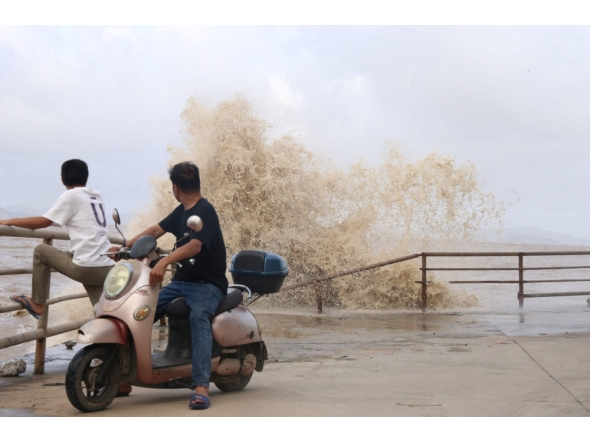 People look on as large waves crash against the coast amid weather patterns from approaching Typhoon Bavi in Wenling city, Taizhou, China's eastern Zhejiang province on July 10, 2026. (Photo by CN-STR / AFP)
 