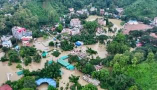 This aerial photograph shows partially submerged residential buildings following heavy rains in Bangladesh's Bandarban town on July 11, 2026. (Photo by Syed Amir Hosain Masum / AFP)