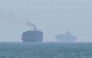 This frame grab taken from AFPTV video footage on July 12, 2026, shows cargo ships anchoring near the Strait of Hormuz off the eastern coast of the United Arab Emirates at Khor Fakkan. (Photo by AFPTV / AFP) 