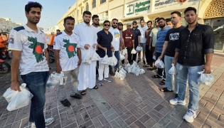 Volunteers from Qatar Probashi Bondhushava distribute refreshments among delivery riders.