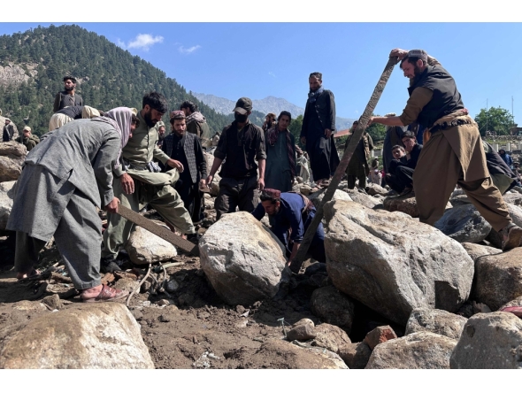 Afghan men search the debris of destroyed shops following flash floods in Parun town in Afghanistan's Nuristan province, on July 21, 2026. (Photo by AFP)