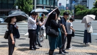 People carry umbrellas to shelter from the sun in Tokyo on July 23, 2026. (Photo by Andrew Caballero-Reynolds/ AFP)
 