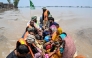 People sitting on a rescue boat ride through a flooded area after heavy monsoon rains induced a rise in the water level of the River Ravi in Muridke on July 27, 2026. (Photo by Arif ALI / AFP)
