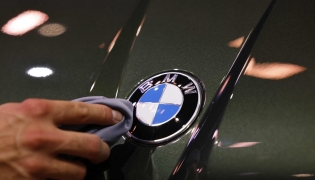 (Files) A staff member cleans the car logo of a BMW at the International Motor Show IAA on September 8, 2025, in Munich, southern Germany. (Photo by Alexandra Beier / AFP)
 