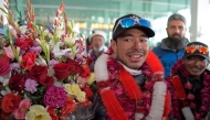 (Files) Nepal's climber Nirmal Purja (C) watches upon his arrival along with his team at the airport in Islamabad on January 21, 2021. (Photo by Farooq Naeem / AFP)