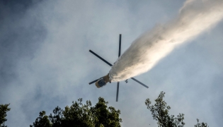 A firefighting helicopter drops water over a wildfire in the area of Porto Germeno, some 70 kilometres (45 miles) northwest of Athens in the region of Viotia, on August 2, 2026. (Photo by Angelos TZORTZINIS / AFP)