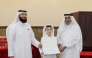 A student receives a certificate from officials at the end of the summer programme.