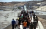 A group of migrants approach the border post to make their way back to Morocco, escorted by Spanish infantry soldiers, in the Spain's north African enclave of Ceuta, on August 2, 2026. (Photo by Henry Nicholls / AFP)