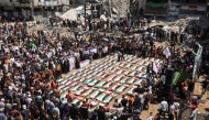 Palestinian mourners attend the funeral of members of the Abu Sharia and Al-Hassaina families, whose remains were recently recovered from the rubble of residential buildings in the al-Sabra neighbourhood which were struck by Israeli bombardments in November 2023, in Gaza City on August 4, 2026. (Photo by Omar AL-QATTAA / AFP)