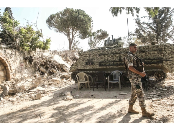 A Lebanese army soldier stands on guard by his armoured vehicle in the southern Lebanese village of Zawtar al-Gharbiyah which was previously badly damaged by the Israeli military on August 8, 2026. (Photo by Mahmoud ZAYYAT / AFP) /