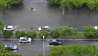 Vehicles drive through a waterlogged street in Wuxi, east China's Jiangsu Province, Aug. 10, 2026. (Photo by Huan Yueliang/Xinhua)