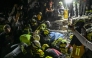 Firefighters and rescue teams carry survivor Daniela Andrea Largo Sanchez out of the rubble of a collapsed building after an earthquake in Pereira, Colombia on August 11, 2026.  (Photo by David SALAZAR / AFP)