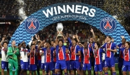 PSG players including Paris Saint-Germain's Brazilian defender #05 Marquinhos celebrate with the trophy after winning the UEFA Supercup football match between Champions League winners Paris Saint Germain (PSG) and Europa League winners Aston Villa in Salzburg, Austria on August 12, 2026. (Photo by FRANCK FIFE / AFP)
