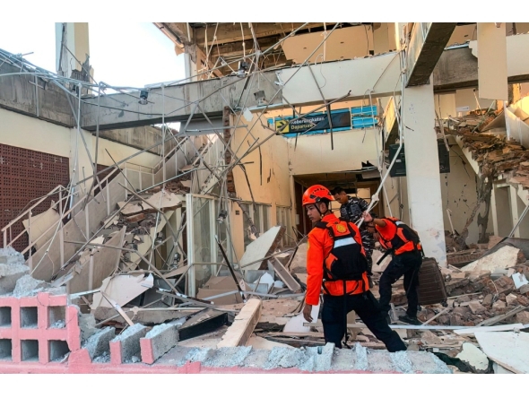This handout picture taken and released on August 15, 2026 by Indonesia's National Search and Rescue Agency (BASARNAS) shows rescuers working amid the rubble of a damaged building after an earthquake in Maumere, East Nusa Tenggara. (Photo by Handout / INDONESIA'S NATIONAL SEARCH AND RESCUE AGENCY (BASARNAS) / AFP)