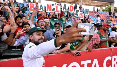 Bangladesh player Mehidy Hasan Miraz poses with fans after victory against Australia on the fourth day of the first cricket Test match between Australia and Bangladesh at Marrara Stadium in Darwin on August 16, 2026. (Photo by William WEST / AFP)