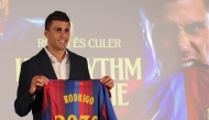Spanish international footballer Rodri poses with a jersey bearing his name during his official presentation as FC Barcelona's new player on August 18, 2026 in Barcelona. (Photo by Lluis GENE / AFP)