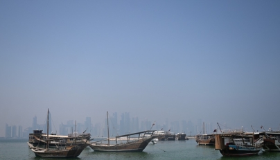 Traditional wooden boats are anchored in front of the Doha skyline on August 19, 2026. (Photo by Mahmud Hams/ AFP)
