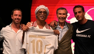Newly recruited Brazilian football player Ronaldinho poses on stage with the jersey of Ravenna FC next to the president of the club, Ignazio Cipriani (R) during the team presentation in Marina di Ravenna on August 20, 2026. (Photo by Stefano RELLANDINI / AFP)
