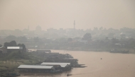 Haze blankets a riverside residential area along the Kahayan River in Palangkaraya, Central Kalimantan, on August 21, 2026, as a result of widespread forest and land fires occurring at various points across the island. (Photo by REINA / AFP)